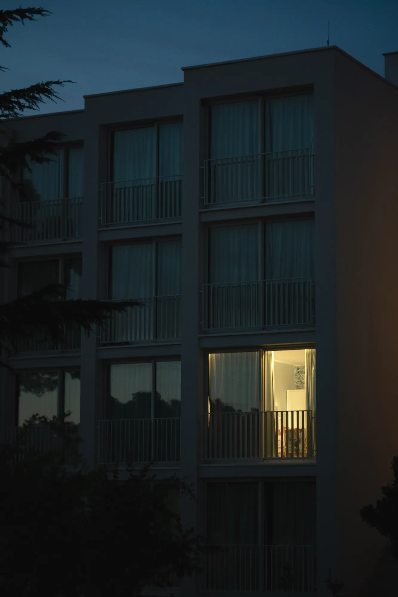 Modern white apartment building with tall balcony windows